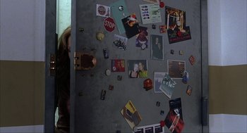 A woman standing in front of a refrigerator covered in magnets
