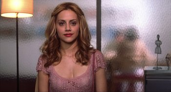 Movie still from “Uptown Girls” (2003), directed by Boaz Yakin – A woman in a pink dress is posing for a picture; Close Up shot, Over the shoulder angle