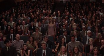 Movie still from “Uptown Girls” (2003), directed by Boaz Yakin – A crowd of people sitting and standing in a room; Wide shot, High angle