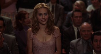 Movie still from “Uptown Girls” (2003), directed by Boaz Yakin – A woman in a pink dress standing in front of a group of people; Close Up shot, Over the shoulder angle