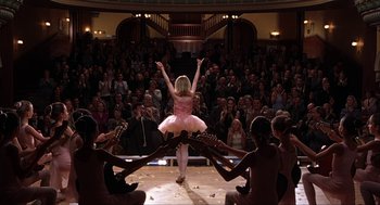 Movie still from “Uptown Girls” (2003), directed by Boaz Yakin – A little girl in a pink dress performing on a stage; Wide shot, Low angle
