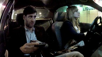 Movie still from “V/H/S/2” (2013), directed by Timo Tjahjanto – A man and a woman sitting in the back of a car; Medium shot, Over the shoulder angle