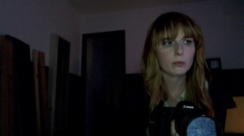 Movie still from “V/H/S/2” (2013), directed by Timo Tjahjanto – A woman is taking a picture in a dark room; Close Up shot, Low angle