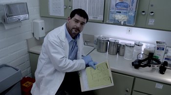 Movie still from “V/H/S/2” (2013), directed by Timo Tjahjanto – A man in a white lab coat holding a piece of paper; Medium shot, Low angle