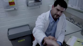 Movie still from “V/H/S/2” (2013), directed by Timo Tjahjanto – A man wearing a lab coat sitting next to a trash can; Medium shot, Over the shoulder angle