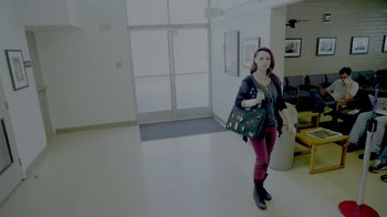 Movie still from “V/H/S/2” (2013), directed by Timo Tjahjanto – A woman standing in a room holding a purse; Wide shot, Low angle