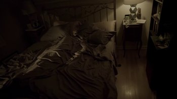 Movie still from “V/H/S/2” (2013), directed by Timo Tjahjanto – A bed that has been unmade in a dark room; Wide shot, High angle