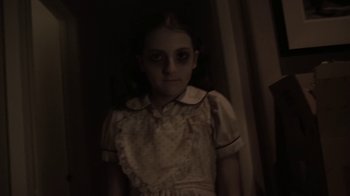 Movie still from “V/H/S/2” (2013), directed by Timo Tjahjanto – A young girl in a dress is standing in a dark room; Close Up shot, High angle