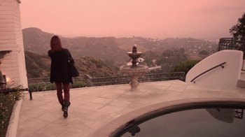 Movie still from “V/H/S/2” (2013), directed by Timo Tjahjanto – A woman standing on a patio looking at a fountain; Extreme Wide shot, High angle