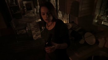 Movie still from “V/H/S/2” (2013), directed by Timo Tjahjanto – A woman holding a cell phone in a dark room; Medium shot, High angle