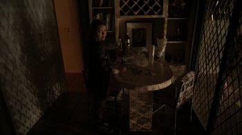 Movie still from “V/H/S/2” (2013), directed by Timo Tjahjanto – A little girl standing at a table in a dark room; Wide shot, High angle