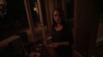 Movie still from “V/H/S/2” (2013), directed by Timo Tjahjanto – A woman is holding a piece of paper in her hand; Medium shot, High angle