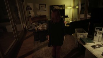 Movie still from “V/H/S/2” (2013), directed by Timo Tjahjanto – A woman standing in a living room in front of a television; Wide shot, High angle