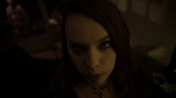 Movie still from “V/H/S/2” (2013), directed by Timo Tjahjanto – A person's face in a dark room; Close Up shot, Low angle