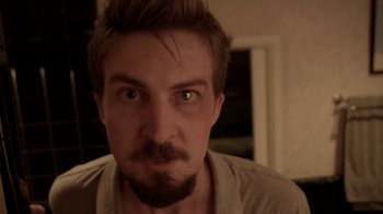 Movie still from “V/H/S/2” (2013), directed by Timo Tjahjanto – A person with a beard; Close Up shot, High angle