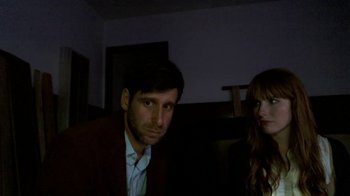 Movie still from “V/H/S/2” (2013), directed by Timo Tjahjanto – A man and a woman are standing in a room; Medium shot, High angle