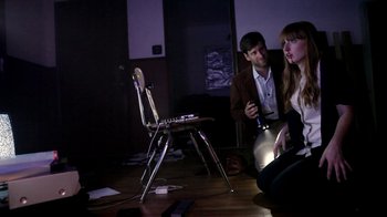 Movie still from “V/H/S/2” (2013), directed by Timo Tjahjanto – A man and a woman sitting on the floor in a room; Medium shot, High angle