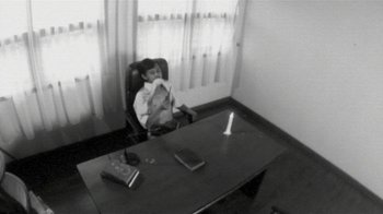 Movie still from “V/H/S/2” (2013), directed by Timo Tjahjanto – A boy sitting at a desk in an office setting; Wide shot, High angle