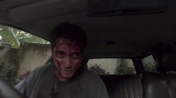 Movie still from “V/H/S/2” (2013), directed by Timo Tjahjanto – A man with blood all over his face in the back of a car; Close Up shot, High angle