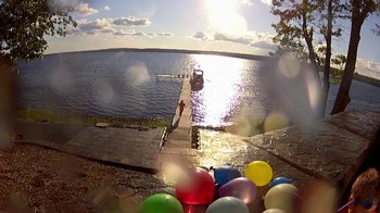 Movie still from “V/H/S/2” (2013), directed by Timo Tjahjanto – A pier with balloons floating in the water near a dock; Extreme Wide shot, High angle