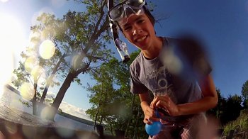 Movie still from “V/H/S/2” (2013), directed by Timo Tjahjanto – A young man wearing goggles and holding a blue object; Medium shot, Low angle
