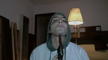 Movie still from “V/H/S/2” (2013), directed by Timo Tjahjanto – A man holding a gun up to his mouth; Close Up shot, High angle