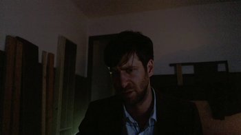 Movie still from “V/H/S/2” (2013), directed by Timo Tjahjanto – A person wearing a suit and glasses; Close Up shot, Low angle