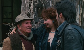 Movie still from “Vagabond” (1985), directed by Agnès Varda – An old man and two young men standing next to each other; Medium shot, Over the shoulder angle