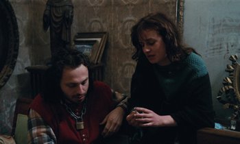 Movie still from “Vagabond” (1985), directed by Agnès Varda – A man and a woman looking at something on a table; Medium shot, High angle