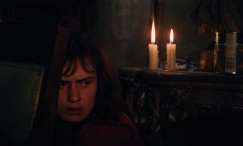 Movie still from “Vagabond” (1985), directed by Agnès Varda – A young woman sitting in front of two lit candles; Close Up shot, High angle
