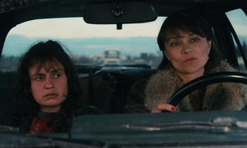Movie still from “Vagabond” (1985), directed by Agnès Varda – Two women sitting in the back seat of a car; Close Up shot, High angle