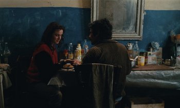 Movie still from “Vagabond” (1985), directed by Agnès Varda – A man and a woman are sitting at a table; Medium shot, Over the shoulder angle