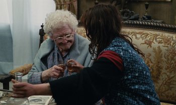 Movie still from “Vagabond” (1985), directed by Agnès Varda – An older woman sitting next to a younger woman holding a drink; Medium shot, Over the shoulder angle