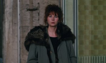 Movie still from “Vagabond” (1985), directed by Agnès Varda – A woman in a coat with a furry collar; Close Up shot, Over the shoulder angle