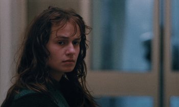 Movie still from “Vagabond” (1985), directed by Agnès Varda – A woman with wet hair is looking into the distance; Close Up shot, Over the shoulder angle