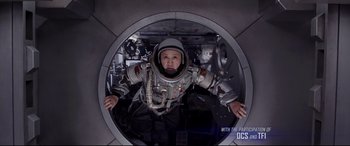 Movie still from “Valerian and the City of a Thousand Planets” (2017), directed by Luc Besson – A person wearing a space suit inside a space station; Medium shot, Overhead angle