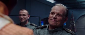 Movie still from “Valerian and the City of a Thousand Planets” (2017), directed by Luc Besson – A man in a gray jacket is looking at the camera; Close Up shot, Over the shoulder angle