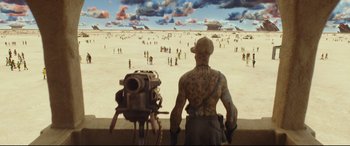 Movie still from “Valerian and the City of a Thousand Planets” (2017), directed by Luc Besson – A man standing next to a robot in the desert; Extreme Wide shot, High angle
