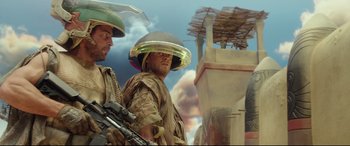 Movie still from “Valerian and the City of a Thousand Planets” (2017), directed by Luc Besson – Two men in military uniforms and helmets are standing in front of a building; Medium shot, Low angle