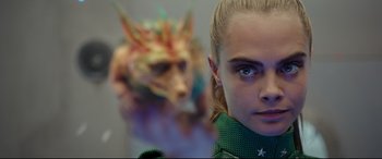 Movie still from “Valerian and the City of a Thousand Planets” (2017), directed by Luc Besson – A person's face with a mask behind them; Close Up shot, Over the shoulder angle