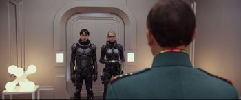 Movie still from “Valerian and the City of a Thousand Planets” (2017), directed by Luc Besson – A man and a woman are standing in front of a door; Medium shot, Low angle