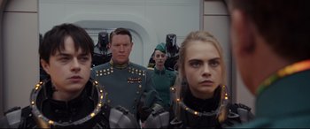 Movie still from “Valerian and the City of a Thousand Planets” (2017), directed by Luc Besson – A group of people standing next to each other in a room; Medium shot, Over the shoulder angle