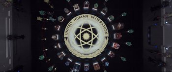 Movie still from “Valerian and the City of a Thousand Planets” (2017), directed by Luc Besson – A group of people standing around a logo of the united human federation; Extreme Wide shot, Overhead angle