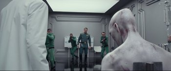 Movie still from “Valerian and the City of a Thousand Planets” (2017), directed by Luc Besson – A group of men standing next to each other in a room; Wide shot, Over the shoulder angle