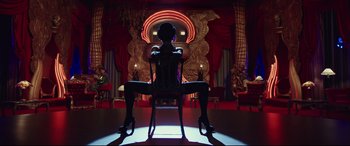 Movie still from “Valerian and the City of a Thousand Planets” (2017), directed by Luc Besson – A person sitting in a chair in a room with lights; Wide shot, Low angle