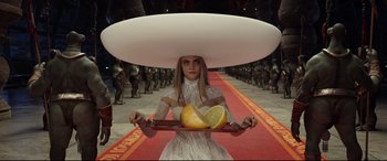 Movie still from “Valerian and the City of a Thousand Planets” (2017), directed by Luc Besson – A woman in a white dress holding a tray of fruit; Medium shot, Overhead angle