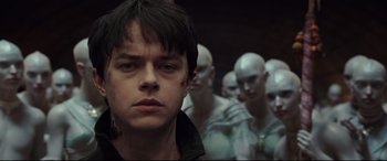Movie still from “Valerian and the City of a Thousand Planets” (2017), directed by Luc Besson – A young man in front of a bunch of other people; Close Up shot, Low angle