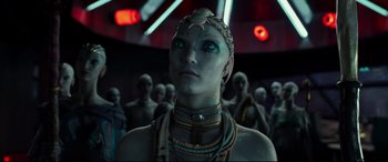 Movie still from “Valerian and the City of a Thousand Planets” (2017), directed by Luc Besson – A woman with a blue face is standing in front of a group of people; Close Up shot, Over the shoulder angle