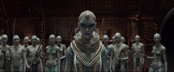 Movie still from “Valerian and the City of a Thousand Planets” (2017), directed by Luc Besson – A group of people standing around a woman in a blue dress; Medium shot, High angle