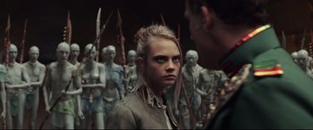 Movie still from “Valerian and the City of a Thousand Planets” (2017), directed by Luc Besson – A woman standing in front of a group of people; Close Up shot, Over the shoulder angle